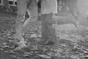 Couples feet beside tree